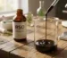 Dark full extract cannabis oil dripping from a glass pipette into a beaker for a what is rso educational guide next to laboratory equipment